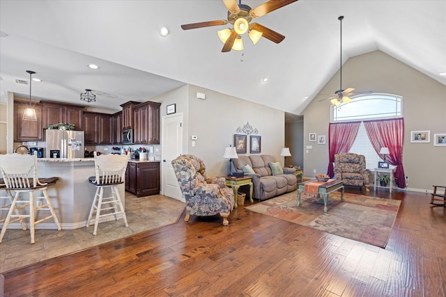 living room with ceiling fan, light hardwood / wood-style floors, and lofted ceiling