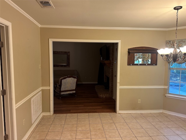 interior space featuring light hardwood / wood-style floors, ornamental molding, and a notable chandelier