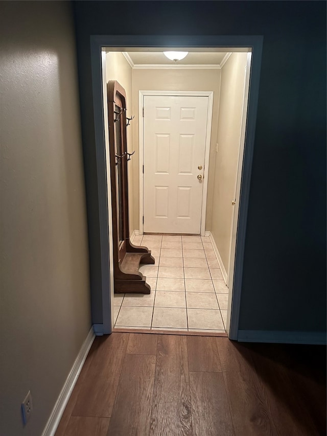 hallway with ornamental molding and light hardwood / wood-style floors