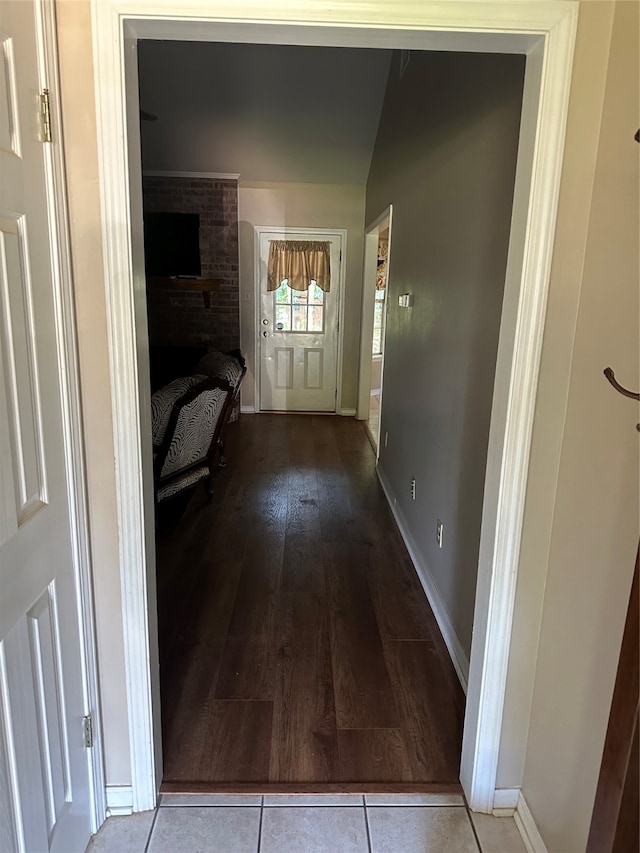 corridor with vaulted ceiling and hardwood / wood-style floors