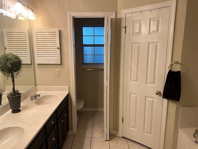 bathroom featuring tile patterned floors, a tub to relax in, vanity, and toilet