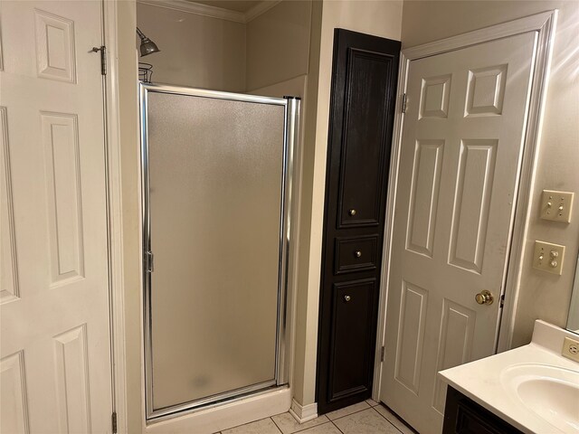 bathroom featuring ornamental molding, a shower with door, vanity, and tile patterned floors