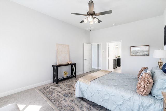 bedroom featuring light carpet, ensuite bath, and ceiling fan