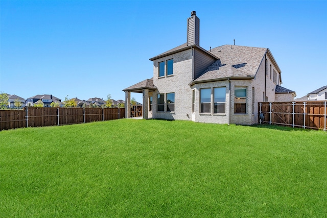 rear view of property with a lawn