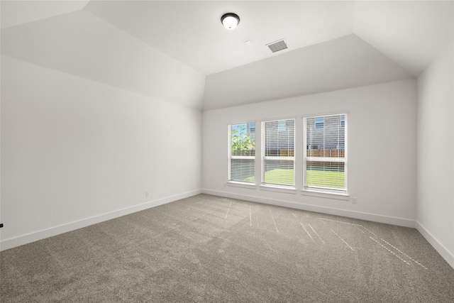 unfurnished room featuring vaulted ceiling and carpet flooring