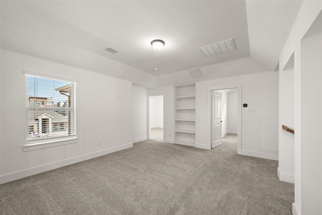 unfurnished bedroom with vaulted ceiling and light carpet