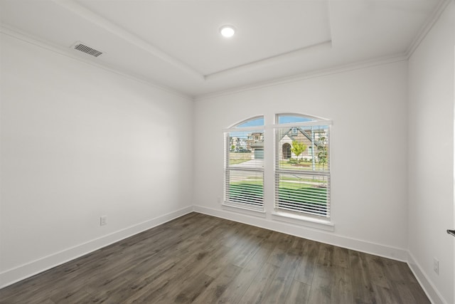spare room with dark wood-style floors, baseboards, visible vents, and a raised ceiling