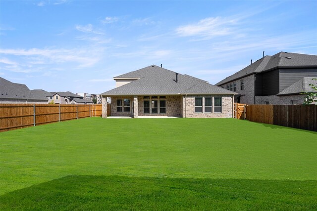 rear view of property with a yard and a patio