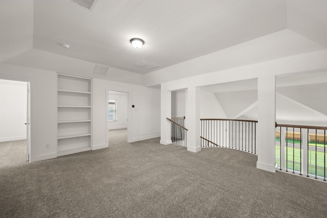 additional living space featuring carpet floors, visible vents, and built in features