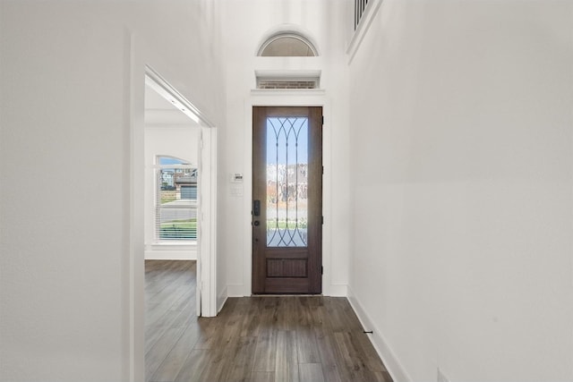 foyer with baseboards and dark wood-type flooring