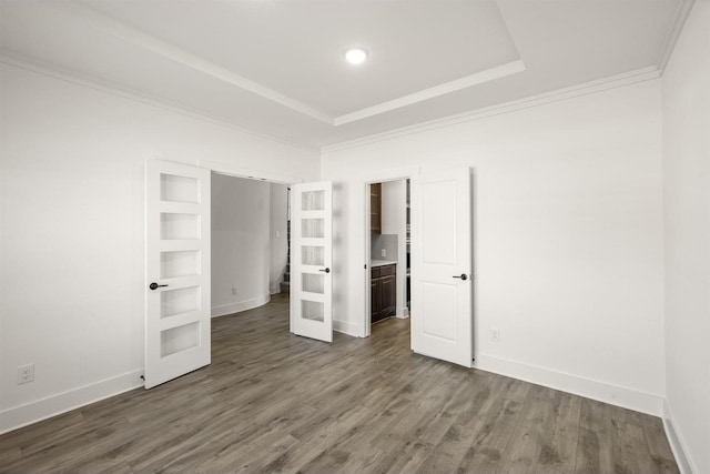 unfurnished bedroom with baseboards, dark wood-style floors, and ornamental molding