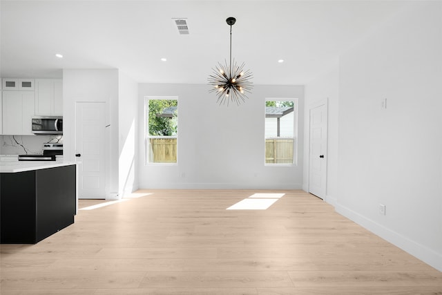 interior space featuring an inviting chandelier and light hardwood / wood-style flooring