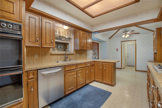 kitchen featuring kitchen peninsula, ceiling fan, appliances with stainless steel finishes, sink, and lofted ceiling