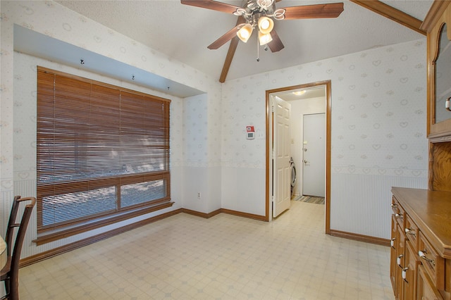 unfurnished room with a wainscoted wall, a textured ceiling, light floors, and wallpapered walls