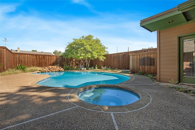 view of swimming pool with an in ground hot tub