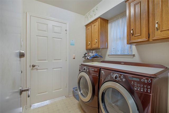 washroom featuring light floors, washing machine and dryer, and cabinet space