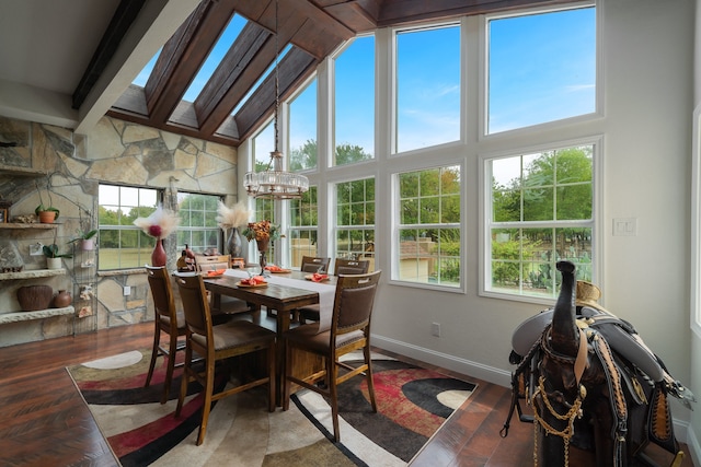 sunroom / solarium with a notable chandelier and lofted ceiling with skylight