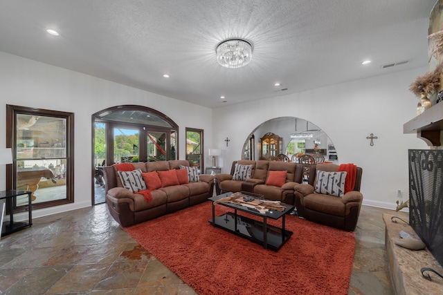 living room with a notable chandelier and a textured ceiling