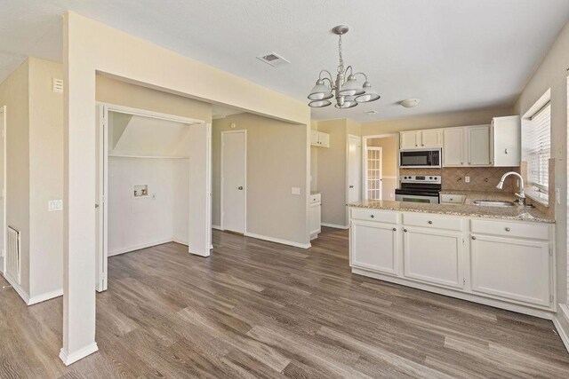 kitchen featuring stainless steel electric stove, a sink, dark wood-style flooring, a chandelier, and white cabinetry