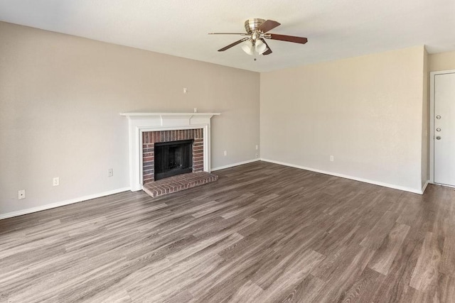 unfurnished living room with baseboards, a ceiling fan, wood finished floors, and a fireplace