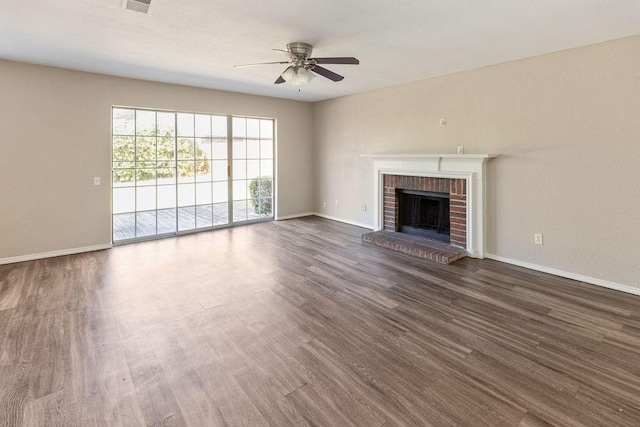 unfurnished living room featuring a fireplace, dark wood finished floors, baseboards, and ceiling fan