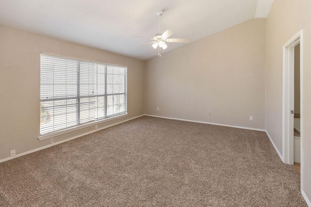carpeted spare room with a ceiling fan, baseboards, and vaulted ceiling