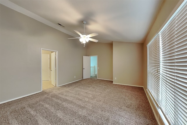 interior space featuring ceiling fan, light colored carpet, and lofted ceiling