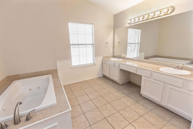 full bath featuring lofted ceiling, tile patterned flooring, a wainscoted wall, and a sink