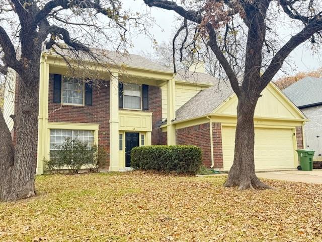 view of front facade featuring brick siding, an attached garage, and driveway
