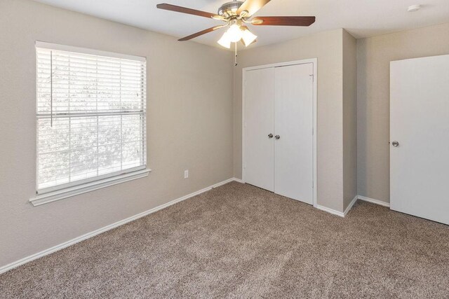 unfurnished bedroom featuring baseboards, carpet flooring, multiple windows, and a closet