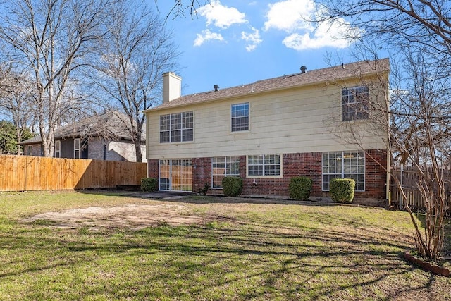 back of house with a chimney, brick siding, fence, and a yard