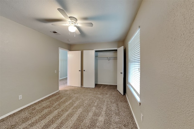 unfurnished bedroom featuring ceiling fan, light carpet, and a closet