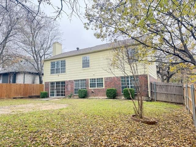 rear view of house featuring a lawn