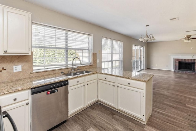 kitchen featuring stainless steel dishwasher, visible vents, a sink, and dark wood-style floors