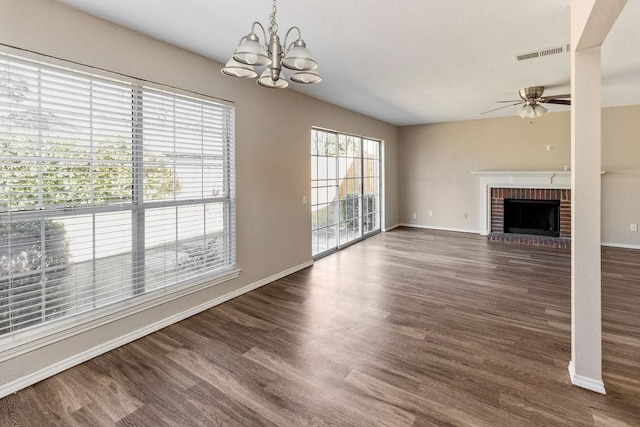 unfurnished living room featuring dark wood finished floors, visible vents, baseboards, and ceiling fan with notable chandelier