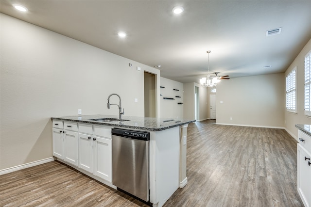 kitchen with dark stone counters, light wood-type flooring, dishwasher, sink, and white cabinets