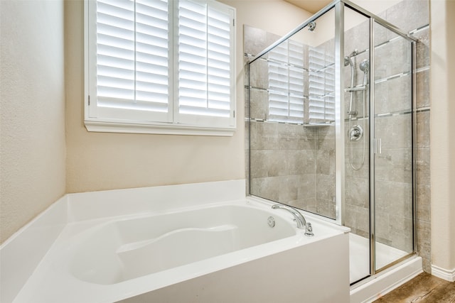 bathroom featuring hardwood / wood-style flooring and plus walk in shower