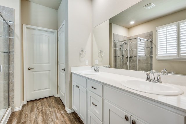 bathroom with a shower with door, vanity, and hardwood / wood-style flooring