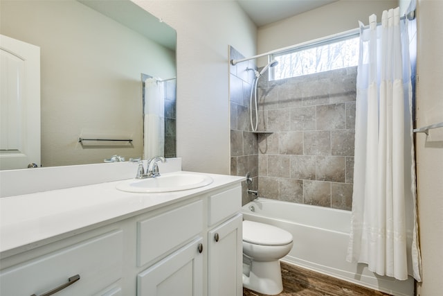 full bathroom featuring hardwood / wood-style floors, vanity, shower / bath combo with shower curtain, and toilet