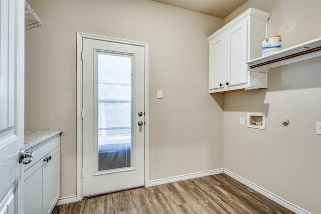 clothes washing area featuring cabinets, hookup for a washing machine, and dark hardwood / wood-style flooring