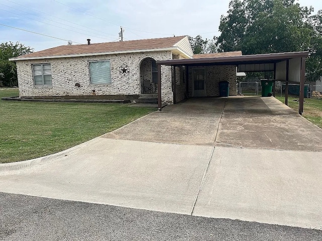 manufactured / mobile home featuring a front yard and a carport