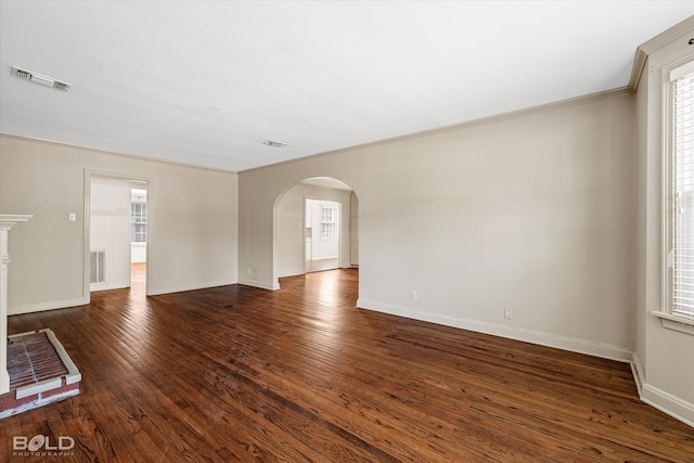 unfurnished living room with ornamental molding and dark hardwood / wood-style floors