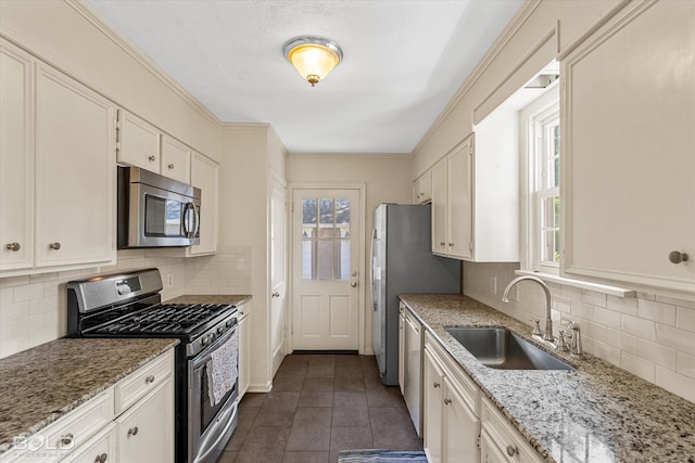 kitchen with a wealth of natural light, white cabinetry, appliances with stainless steel finishes, and sink