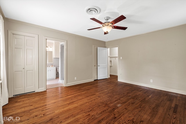 unfurnished bedroom with ornamental molding, dark hardwood / wood-style flooring, ceiling fan, and ensuite bath