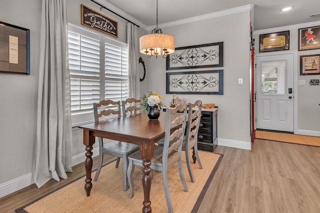 dining space with ornamental molding, a chandelier, and hardwood / wood-style floors