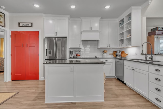 kitchen featuring decorative backsplash, stainless steel appliances, sink, white cabinetry, and light hardwood / wood-style floors