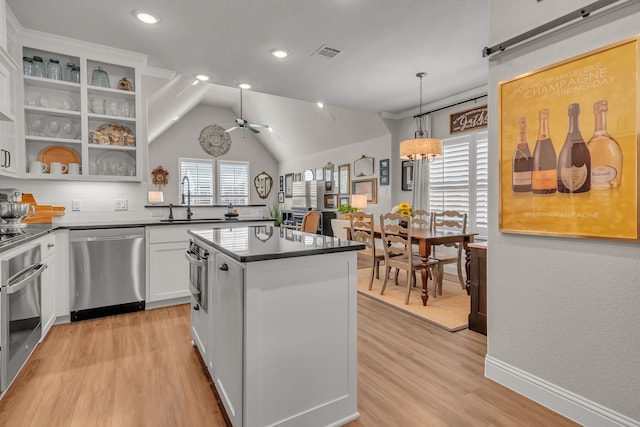 kitchen with sink, ceiling fan with notable chandelier, hanging light fixtures, white cabinetry, and stainless steel appliances