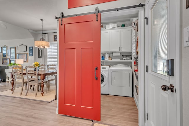 laundry area featuring a barn door, light wood-type flooring, and a wealth of natural light