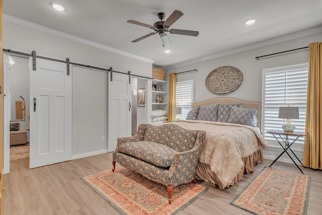 bedroom with light hardwood / wood-style floors, crown molding, a barn door, and ceiling fan