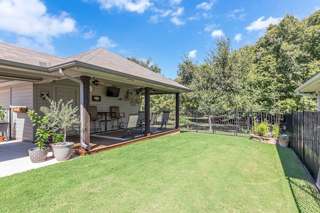 view of yard with a deck and ceiling fan